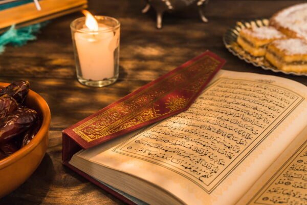 opened-quran-near-candle-sweet-dates_23-2147868960